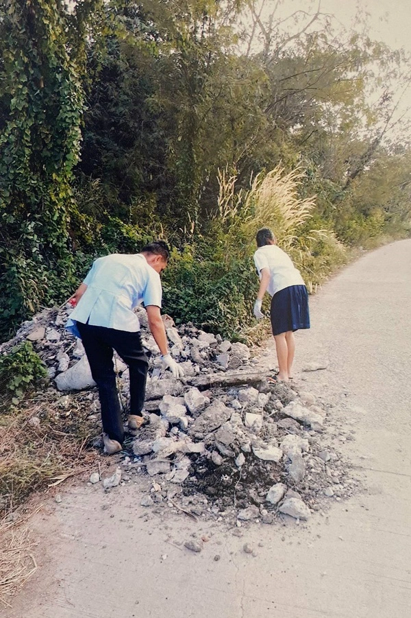 2 พ่อลูกช่วยกันเก็บสิ่งกีดขวางออกจากทางสัญจร หวั่นผู้ใช้ถนนเกิดอันตราย