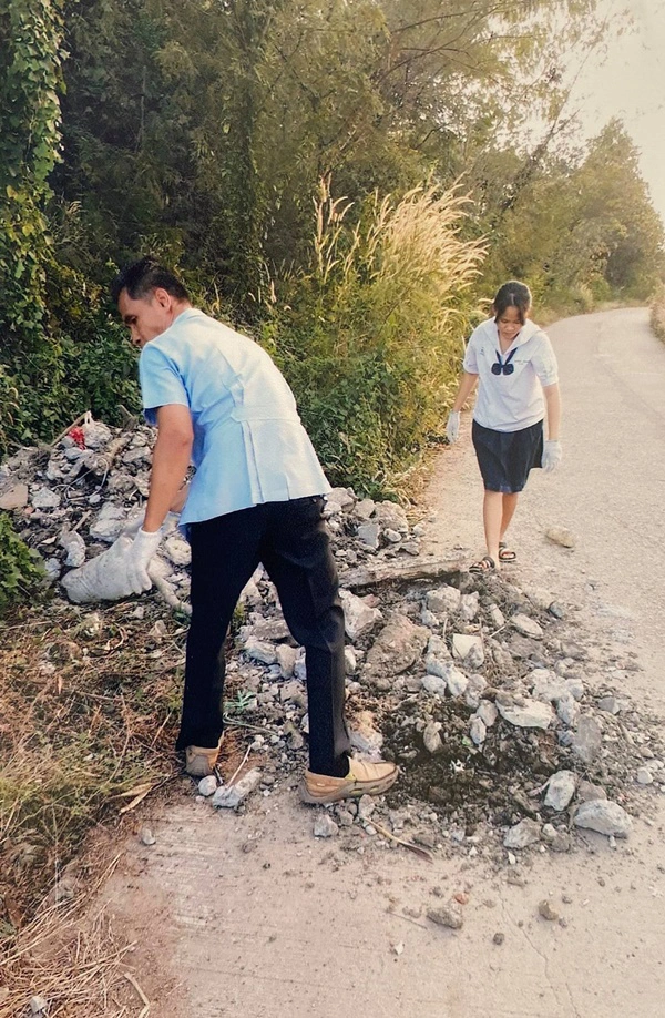2 พ่อลูกช่วยกันเก็บสิ่งกีดขวางออกจากทางสัญจร หวั่นผู้ใช้ถนนเกิดอันตราย